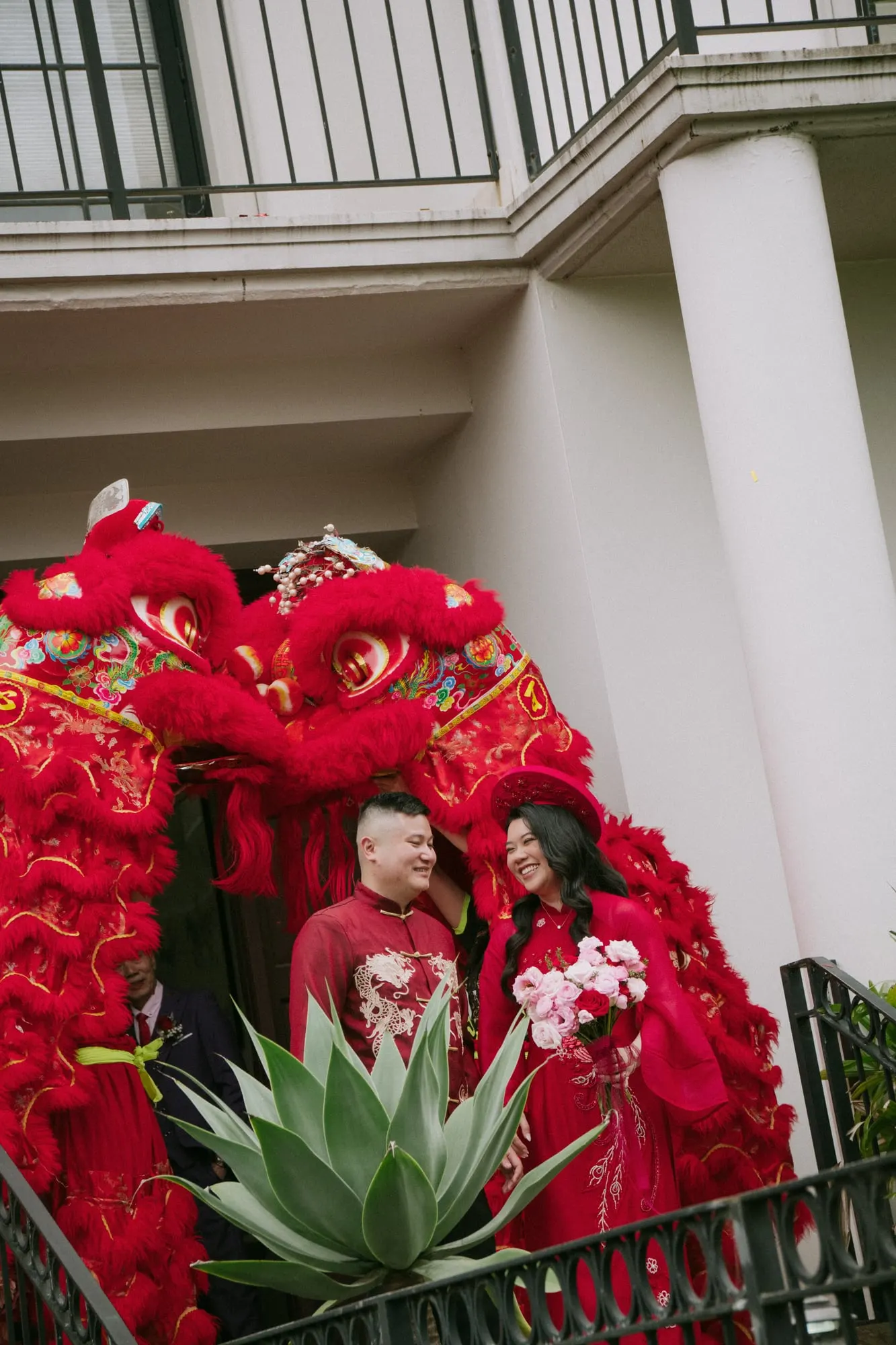 Lion dancers performing in front of the red rose entrance installation