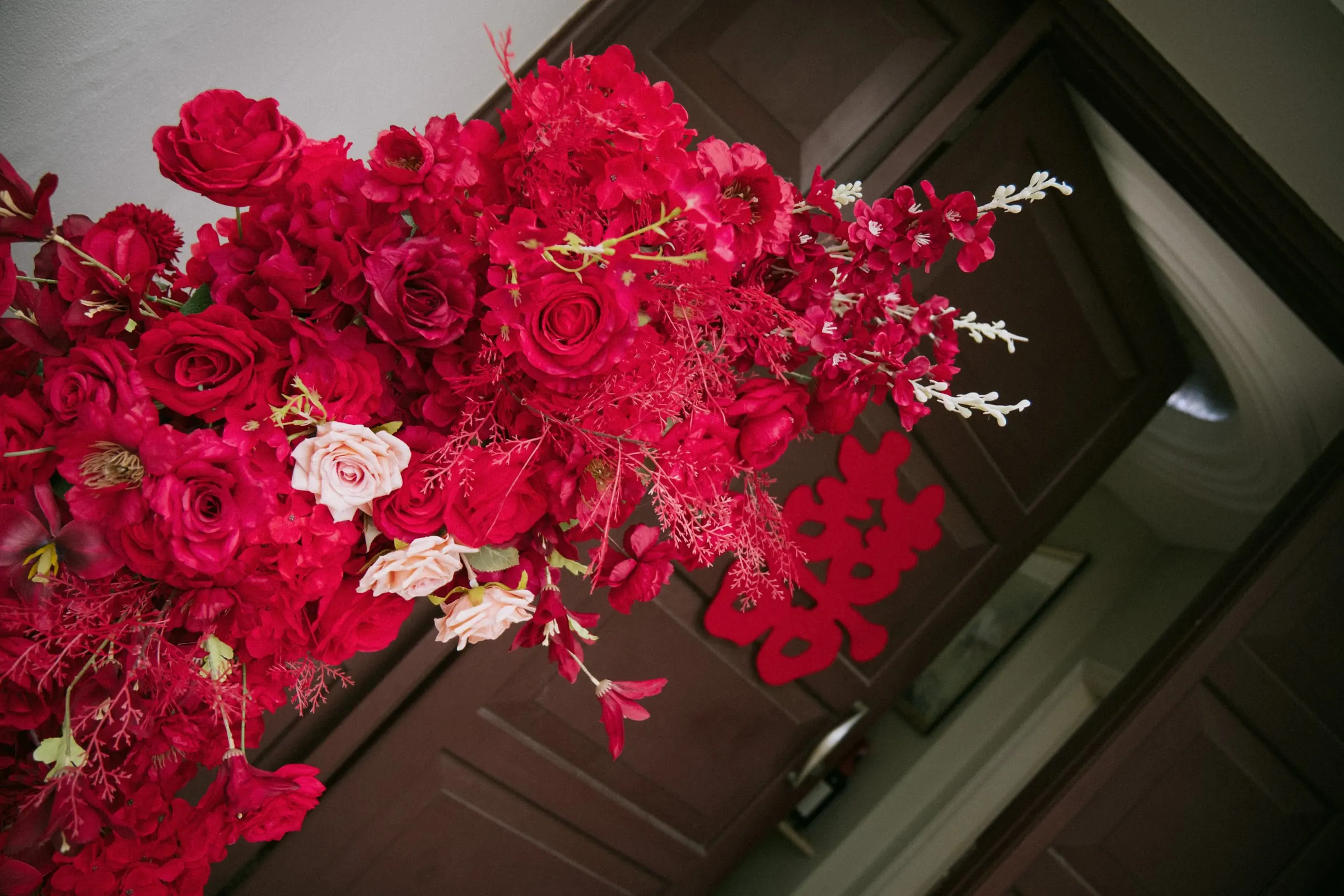 Cascade of red and pink roses on a red drape